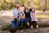 A photograph of Taylor Hampton and Jacinta Daniher and their family in an outdoor environment