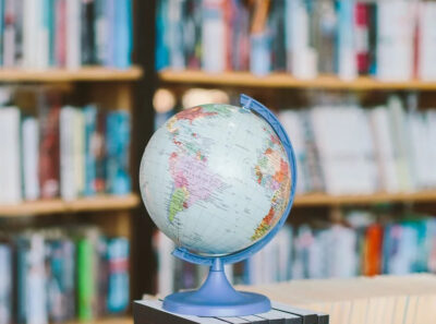 Photograph of a glove in front of shelves of books
