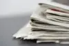 Photograph of a pile of print newspapers