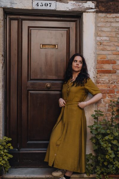 Bronwyn Eley standing on a doorstep in front of a closed wooden door
