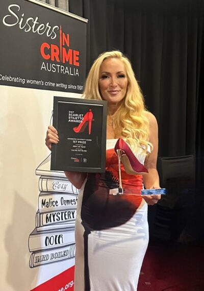 Photograph of Nikki Lee Taylor holding first prize certificate and trophy