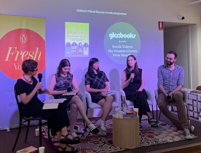 Five people sitting on chairs on a stage