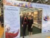 Ambassador to Italy Julianne Cowley and Writing Australia director Wenona Byrne standing in front of the Australian stand at Bologna Children's Book Fair