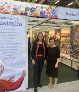 Ambassador to Italy Julianne Cowley and Writing Australia director Wenona Byrne standing in front of the Australian stand at Bologna Children's Book Fair