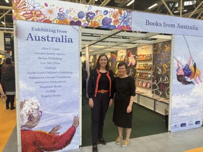 Ambassador to Italy Julianne Cowley and Writing Australia director Wenona Byrne standing in front of the Australian stand at Bologna Children's Book Fair