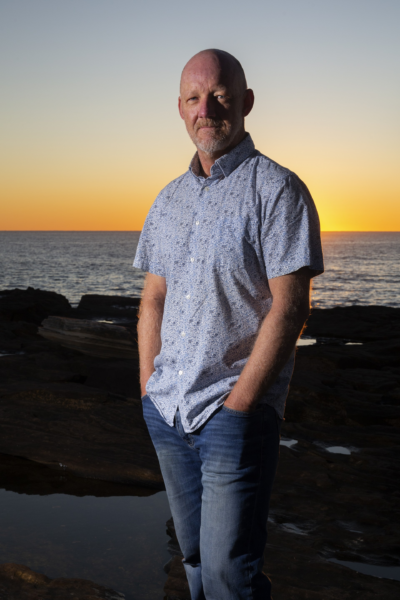 Photograph of Malcolm Knox standing in front of the ocean