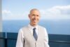 Photograph of Todd Babiak standing in front of the ocean